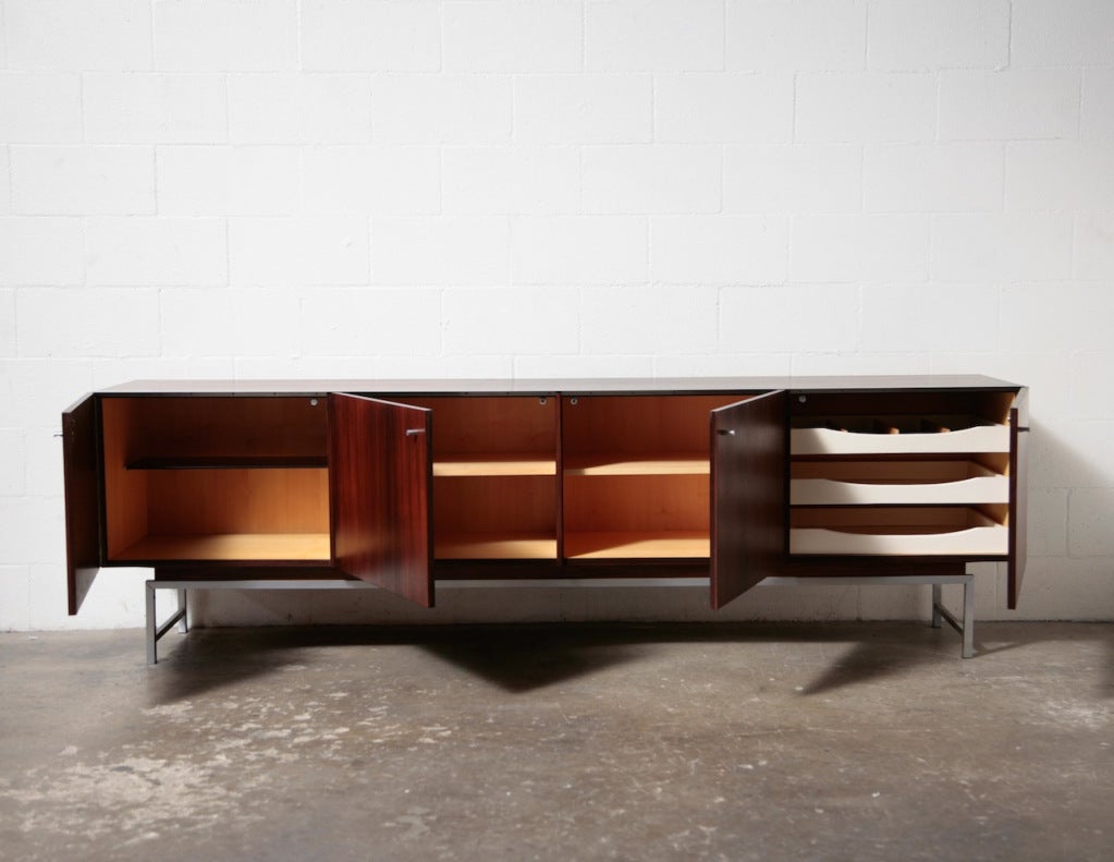 Extremely Long and Sleek Rosewood Credenza with Beautiful Flame Pattern. Birch Interior with White Painted Wood Draws, Felt Lined Flatware Drawer. Aluminum Trim with Brushed Chrome Frame and Door Pulls.