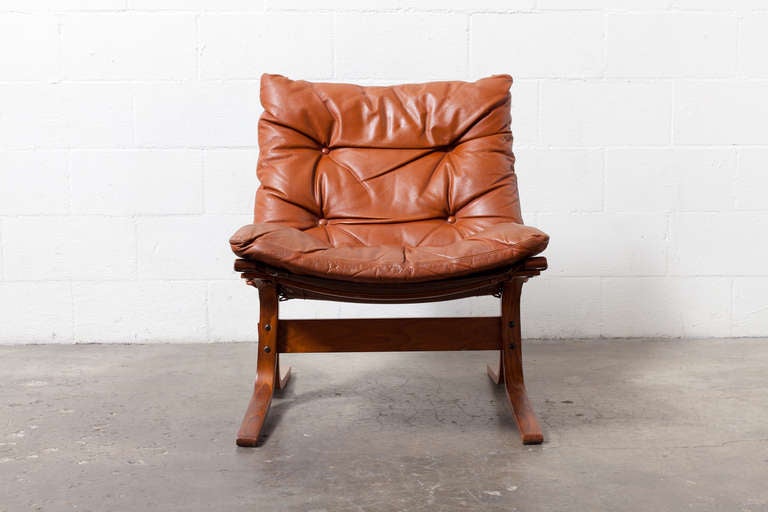Laminated bent wood with teak finish and leather upholstered cushions.