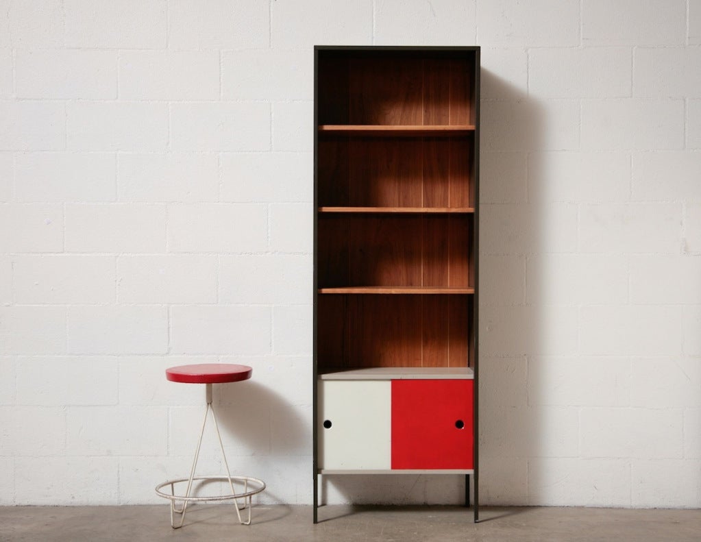 Grey enameled Metal cabinet with Wood Paneled Backing, New Stained Birch Book Shelves over a Small Cabinet with Red and White Enameled Metal Sliding Doors.