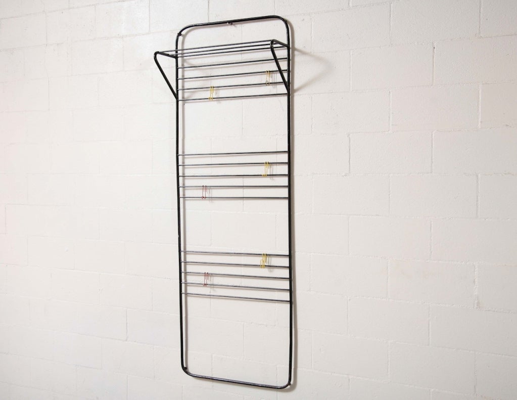 Rare original black enameled tubular metal frame with hat rack and delicate wire hooks in red and yellow by Coen de Vries. He is known as a functionalist designer who strove for good, affordable and modern furniture. De Vries fulfilled a pioneering