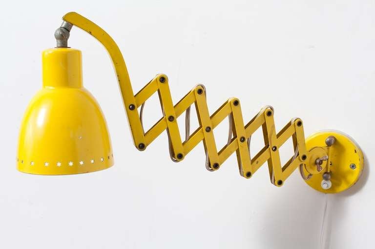 Sunshine Yellow Adjustable Length Enameled Metal Wall Lamp with Unique Accordion-Like Arm and Star Cut-Outs Around Opening of Shade.