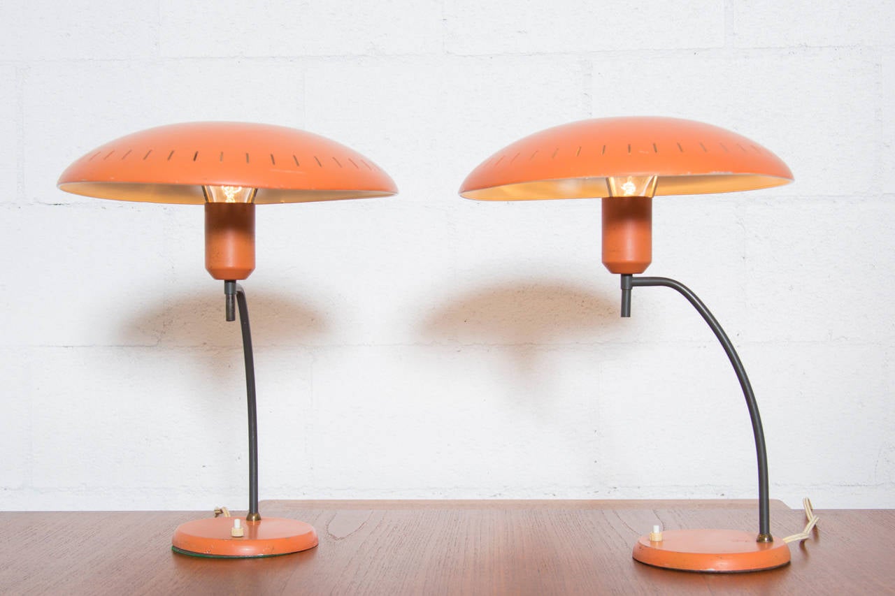 Very special pair of 1950s table lamps by Louis Kalff for Philips. Salmon enameled metal perforated shades with bent metal arm and mercury bulb. In original condition with some visible wear to enamel on base and overall wear consistent with age and