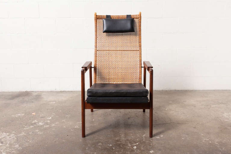 Lounge Chair designed by P. Muntendam for Gebr. Jonkers in 1956. Beautifully Woven Rattan Back and Finished Wood Frame with Skai Upholstered Seat and Headrest Pillow. Slight Rattan Loss, Original Condition.