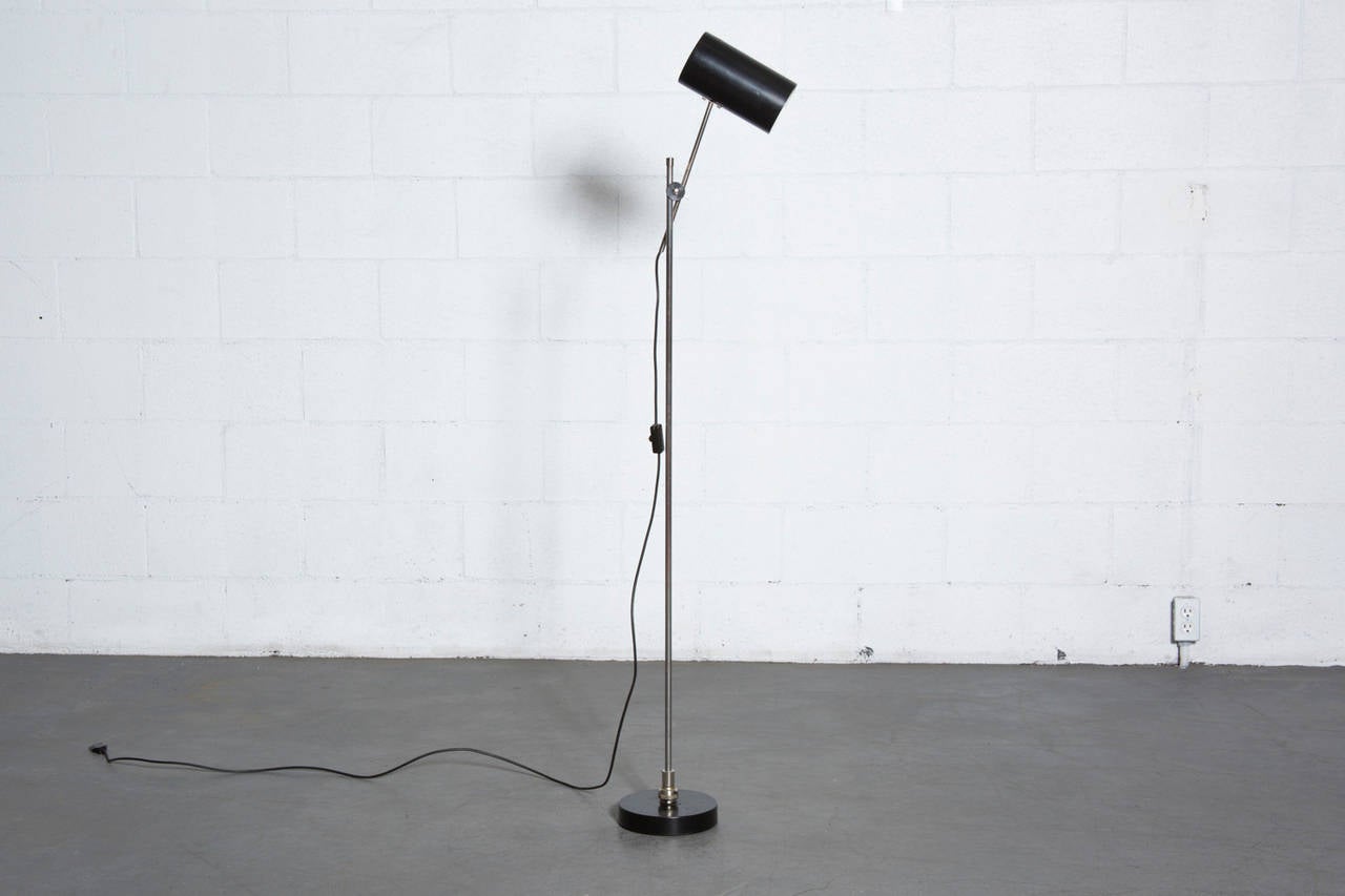 Pivoting hala style floor lamp in black and chrome. The shade measures 8 x 4.5 and the base is 7.5 inches in diameter. In original condition with some visible wear to enamel consistent with age and use.