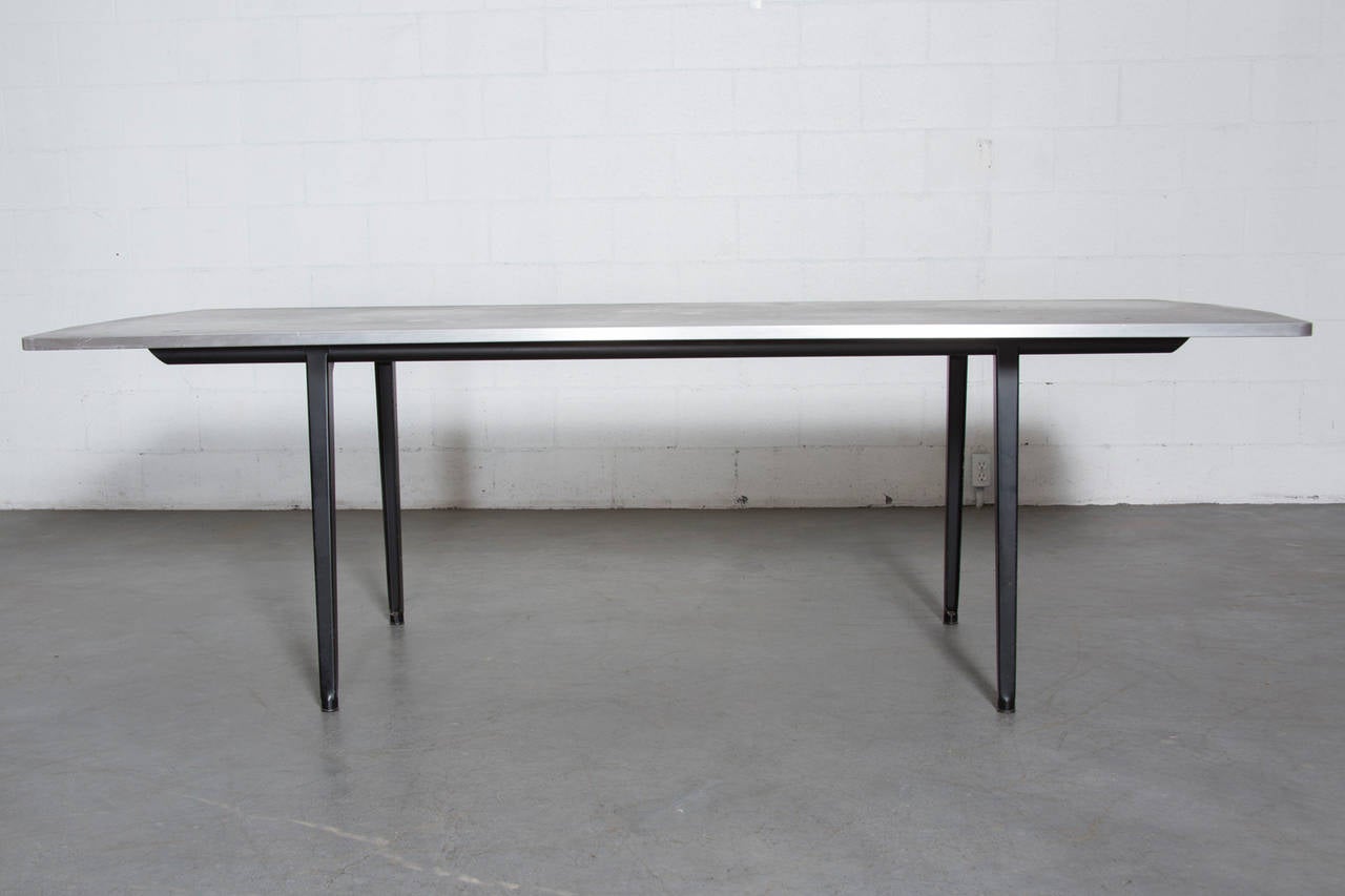 Rare executive conference table with dark grey linoleum top, aluminum edging and black enameled frame. The edges were angled by Friso to accommodate the Chairman and other colleagues who may need to sit at the heads of the table. Original condition