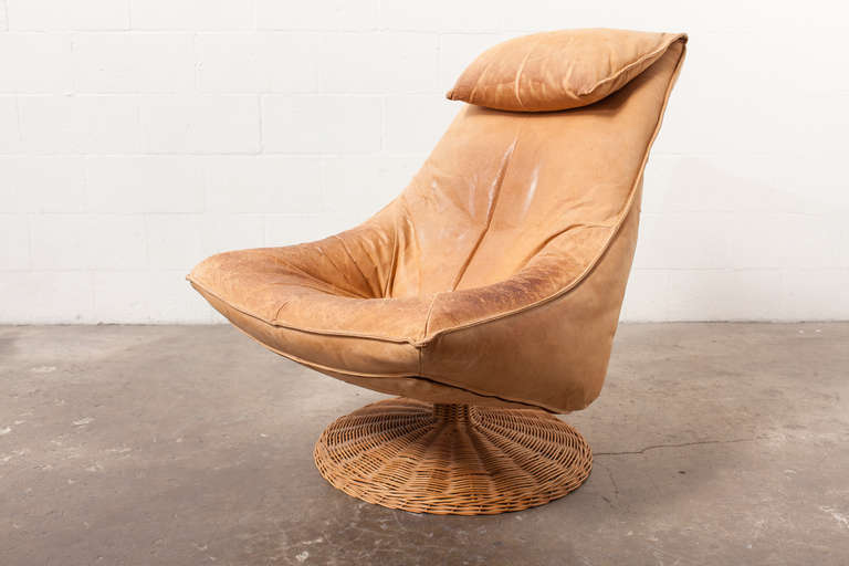 Natural Leather Bodied Lounge Chair on a Woven Rattan Swivel Base. Beautiful Patina. Original Condition.

Gerard Van Den Berg arguably defined a turning point from classic Mid-Century Dutch furniture design to more contemporary design using