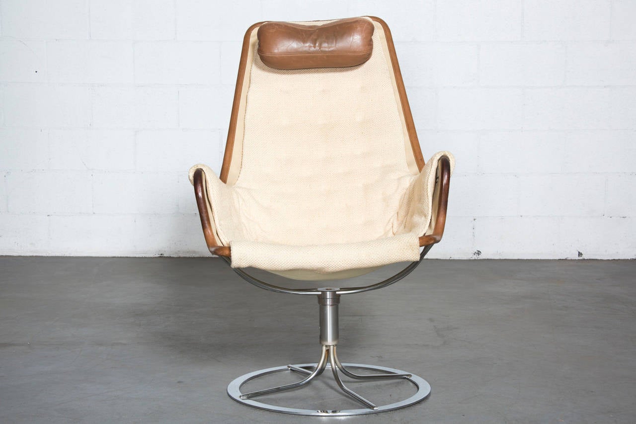 Original Bruno Mathsson Swivel Chair with Chrome Base, Canvas Backing, Leather Trim, Great Tufted Canvas-Like Insert Cushion and Leather Head Rest Pillow. In Good Original Condition with Wear to Upholstery and Patina to Leather Consistent with Age
