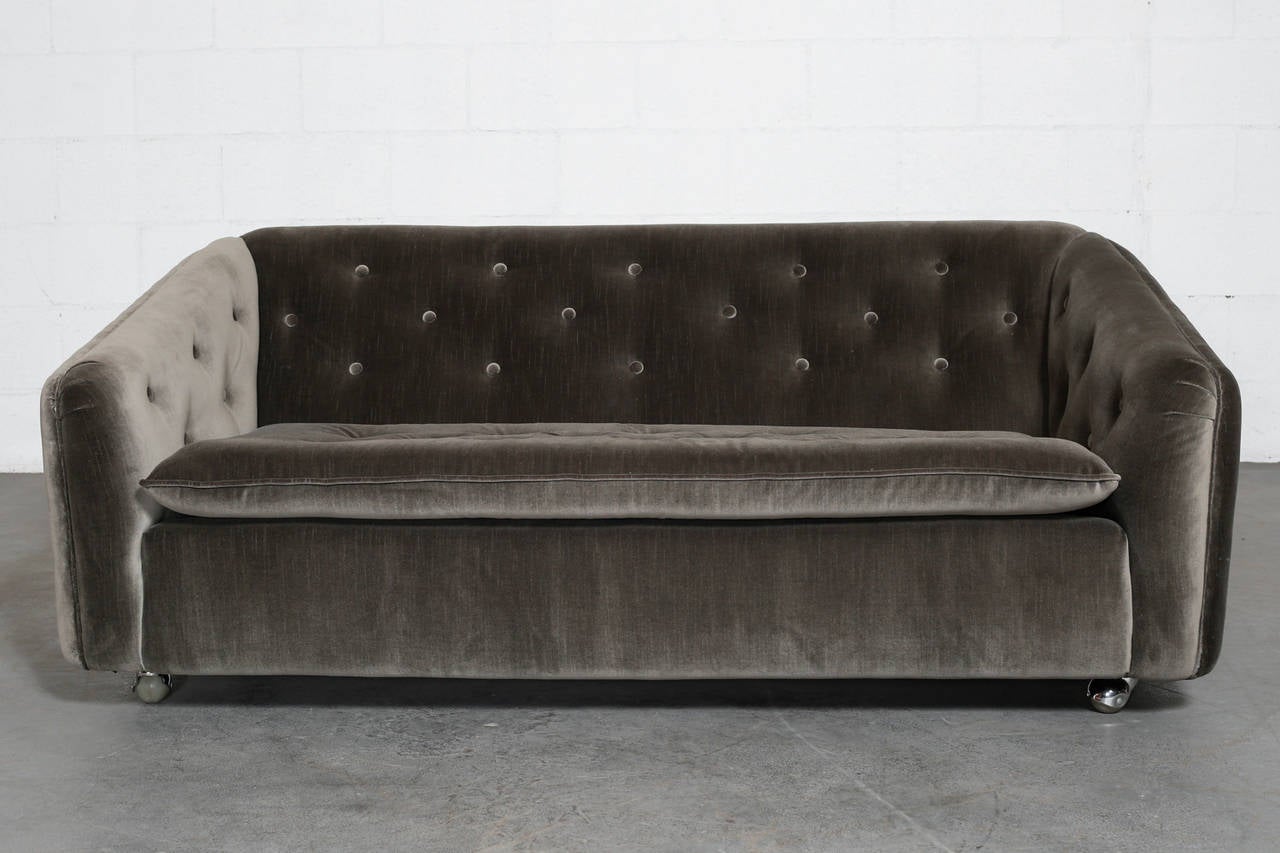 Rolling two-seat seal grey velvet sofa. Newly upholstered with chrome rollers.