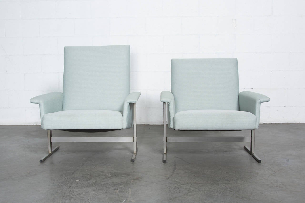 Newly upholstered in cornflower blue fabric with square tubular metal frame. His and her pair from Gelderland, Netherlands. Her chair measures 30 x 33 x 14.25/18/29