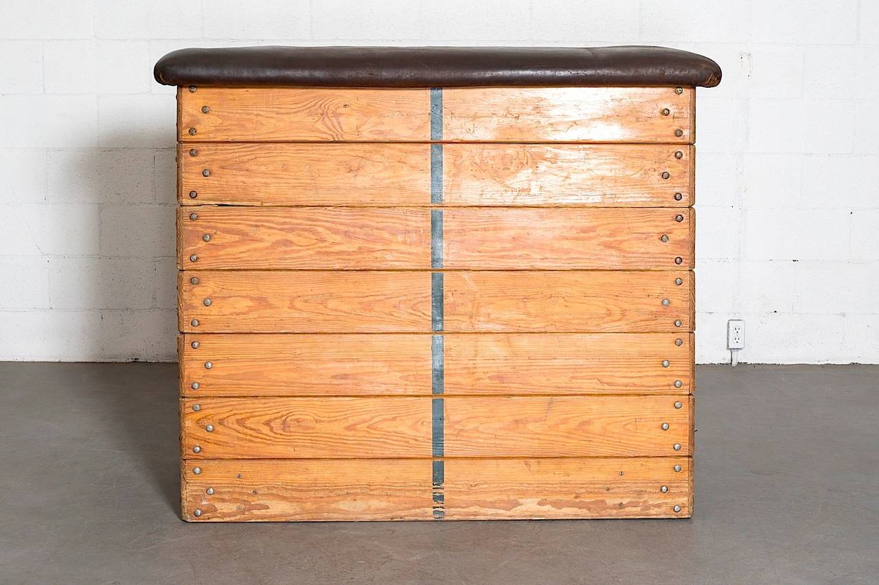 Incredible original tall stacking benches with rolling mechanism and leather cushion. Unstacks into seven pieces. In original condition with visible wear to wood and leather consistent with age and (Gym) use.