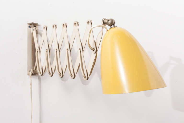 Lemon yellow bullet shade with enameled white accordion arm in original condition.