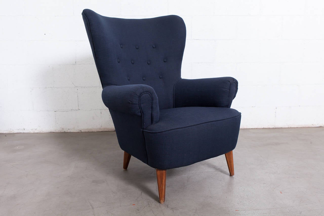 Large Version of this Theo Ruth Wing Back Tufted Armchair in New Navy Blue Fabric. Original Frame, Tapered Wood Feet Show Wear Consistent with Age and Use.