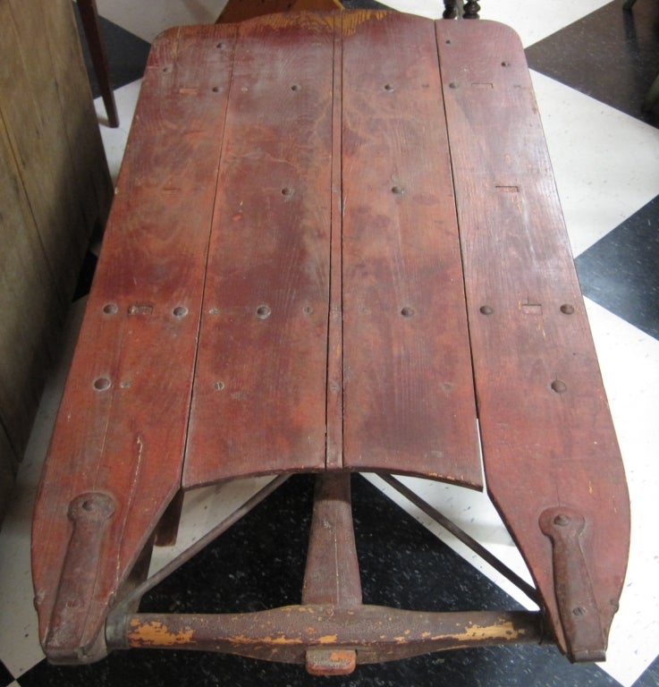Antique work sled converted to a coffee table by adding legs, old red paint, hand-forged iron, early 19th century. Sure to be a conversation piece in any room in which it is placed.