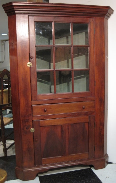 Small Chippendale corner cupboard, poplar, one piece, having a nice old warm finish.

The upper section has a glass door with the original glass, and butterfly shelves in the interior. Below is a single drawer above a paneled door. The cupboard