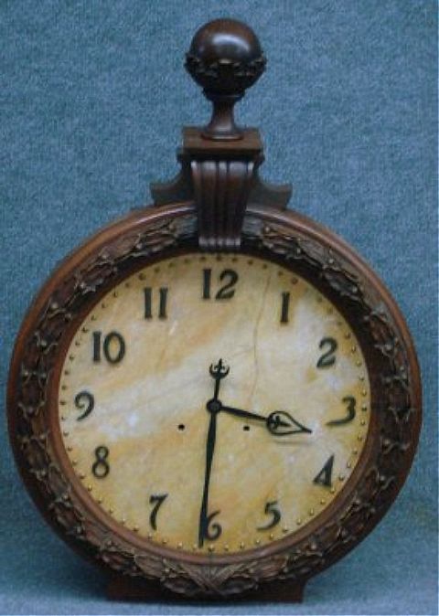Unusual Seth Thomas railroad clock, having a marble face with raised metal numerals, enclosed in a beautifully carved walnut frame. The brass works are stamped with the Seth Thomas logo and are in excellent running condition. The clock is spring