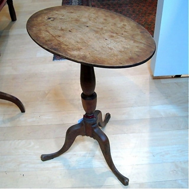 This is an early Queen Anne tilt-top candlestand, constructed of birch. It has an oval top with wonderful patina and an exceptionally appealing base with excellent turnings and great proportions. It dates from circa 1760-1780, and was made in New