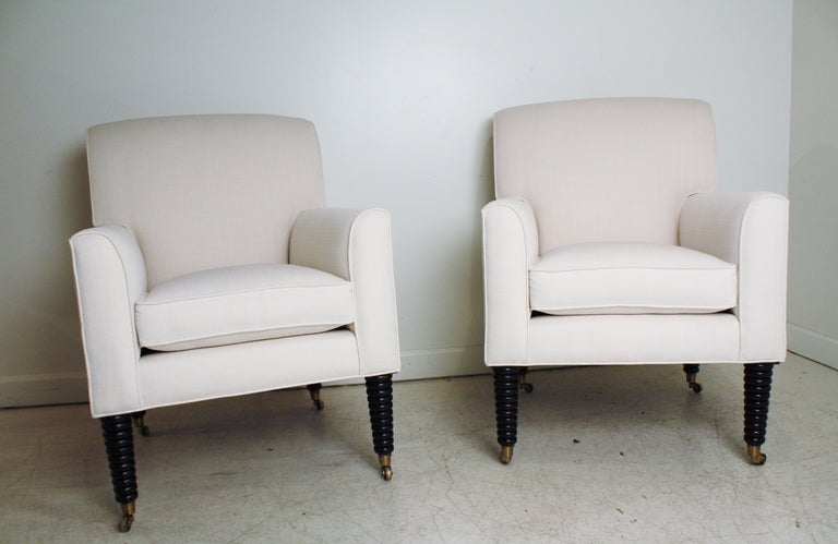 Reupholstered vintage 1940s style Ralph Lauren club chairs in ivory linen.  Ebonized stacked spindle wood legs with brass castors.  All new cushions - extremely comfortable.