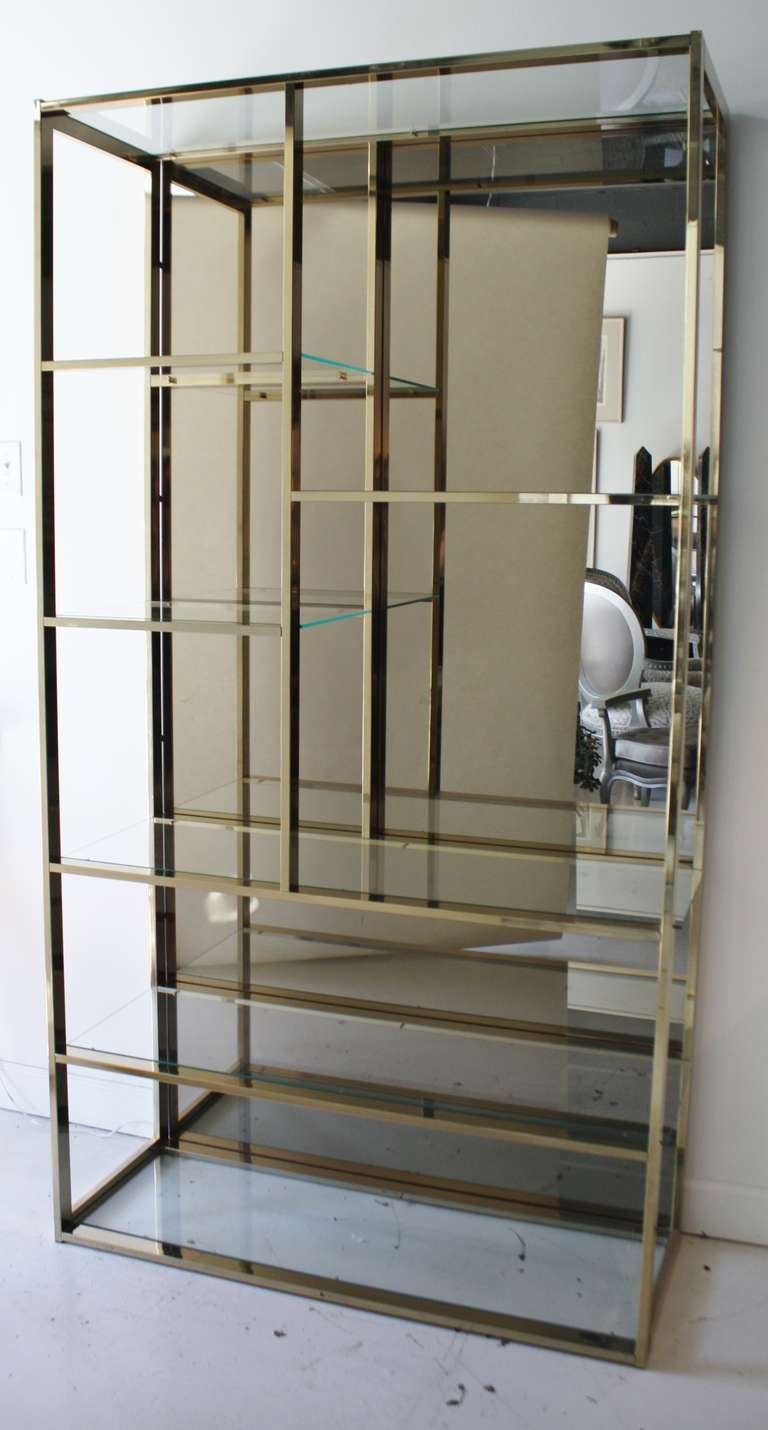 1970s Milo Baughman brass etagere with glass shelves and smoky mirror back panel.  Mirror can be easily removed and attached for shipping.
