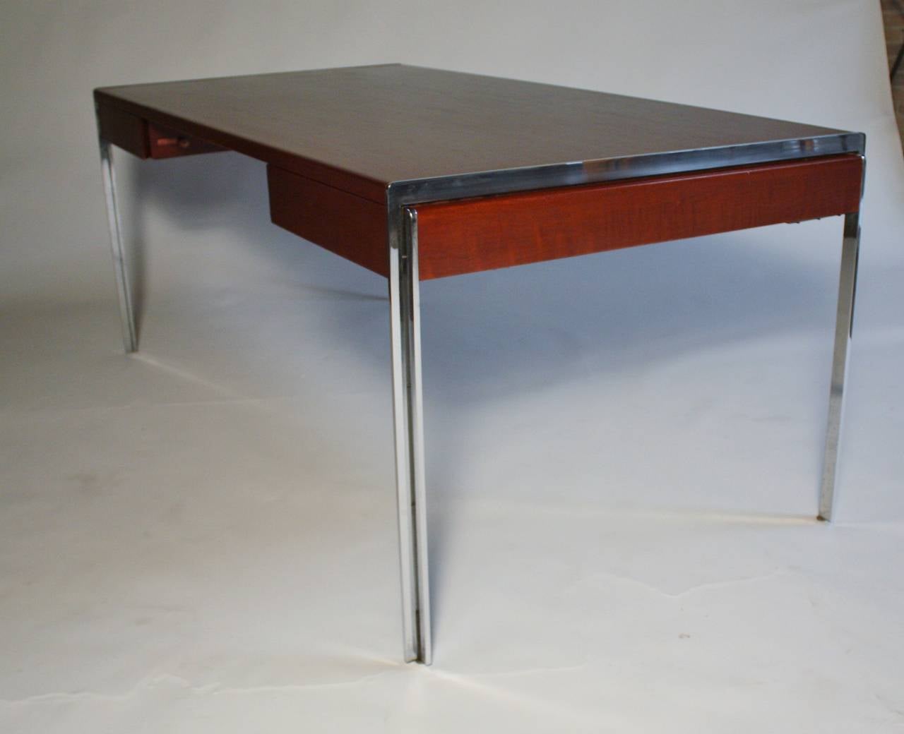 Mid Century modern wood and chrome frame Executive desk by Stow Davis with two pull-out pencil drawers. Drawers lock on its side - no keys. Wood and chrome is clean with minimal wear for it's age.