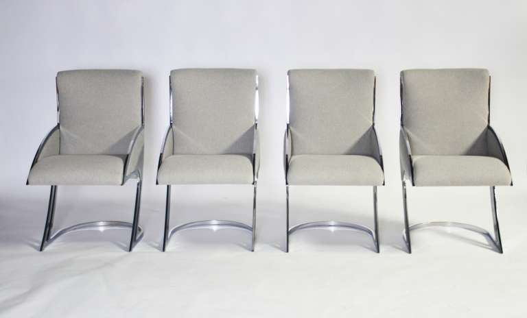 Very rare set of four chrome dining chairs in the style of Milo Baughman or Pierre Cardin. Newly upholstered in a dove gray Italian synthetic wool. Stunning space age design upholstered in a classic neutral fabric. The gray fabric on the arms is one