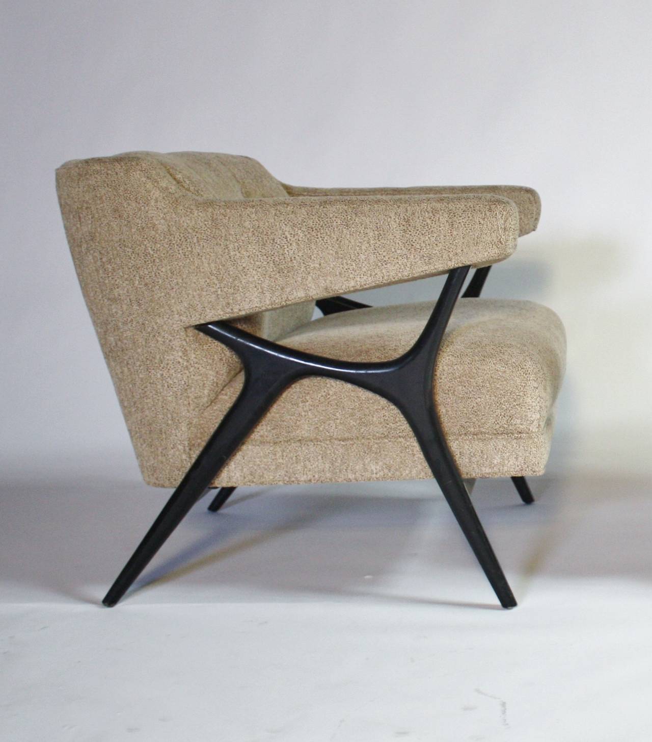 Stunning and unique pair of upholstered lounge armchairs with sculptural ebonized wood frames in the manner of Vladimir Kagan. Upholstered in a textured oatmeal on cream fabric.