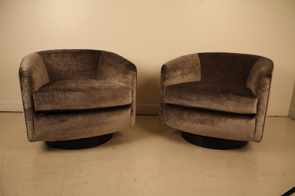 Elegantly reupholstered pair of Milo Baughman swivel club chairs in a stamped grey silk velvet chenille.  Sits very comfortably with new cushions and rotates smoothly to a full 360 degrees.