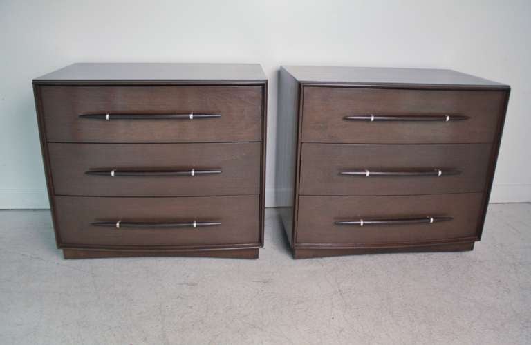 Pair of 3-drawer commodes by T.H. Robsjohn Gibbings for Widdicomb refinished in a warm walnut with a slightly darker finish on the spear handles.  These move easily on tiny castors.  The interior of the top drawer has wood dividers to organize