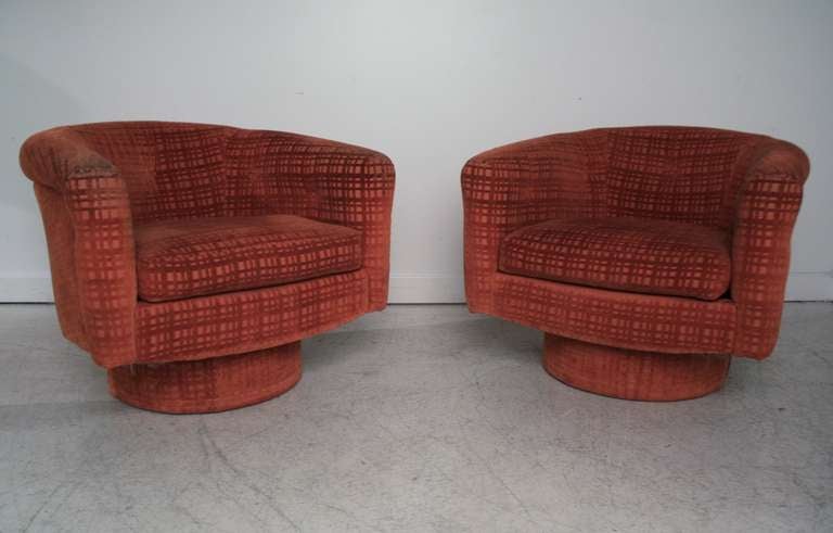 Pair of swivel barrel chairs in the style of Milo Baughman in original textured orange pattern fabric.