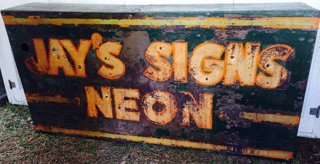 Neon sign maker's sign: Jay's Signs Neon. Richly colored and patinated steel shell for a neon sign promoting the sign-maker Jay. All that's missing is the actual neon tubes that once were there. The holes are drilled. Easily installed by a