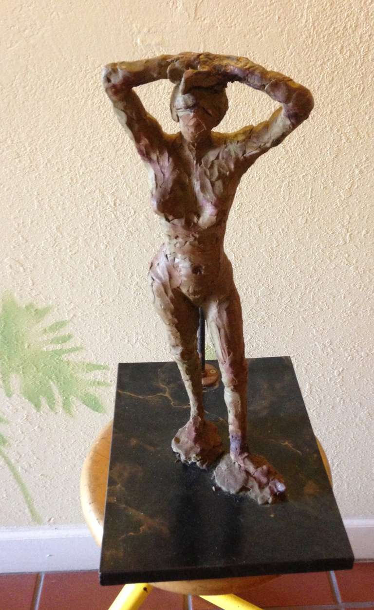 Modèle en argile sur support en marbre de l'interprétation d'une femme nue par un étudiant en art.  En préparation pour la coulée finale en bronze. Il y a une beauté primitive dans cette forme féminine. Une vision terreuse et tactile dans cette