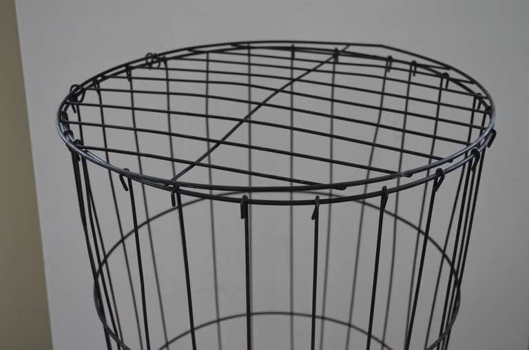 Wire basket with lid projects interesting sculptural shape of concentric circles intersecting straight lines. Diameter of basket telescopes from 14.25