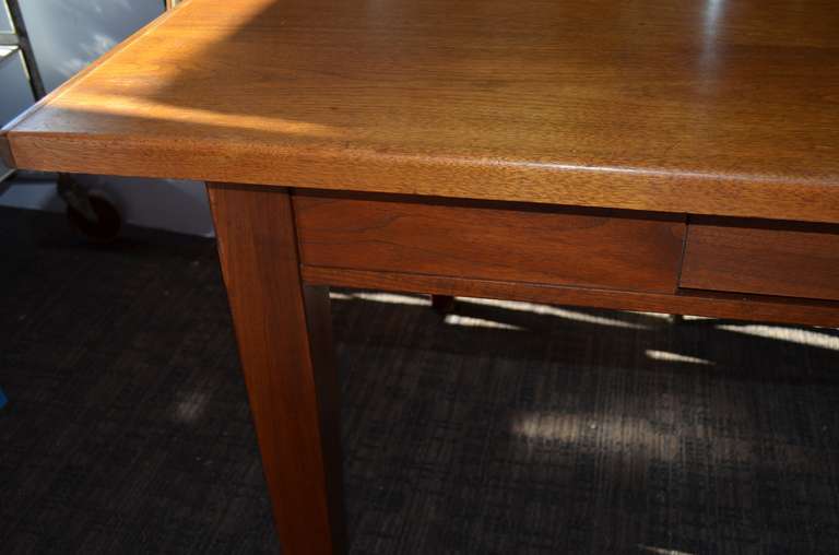 Library table of walnut solids and veneers. Two drawers. Made by Lehigh-Leopold.