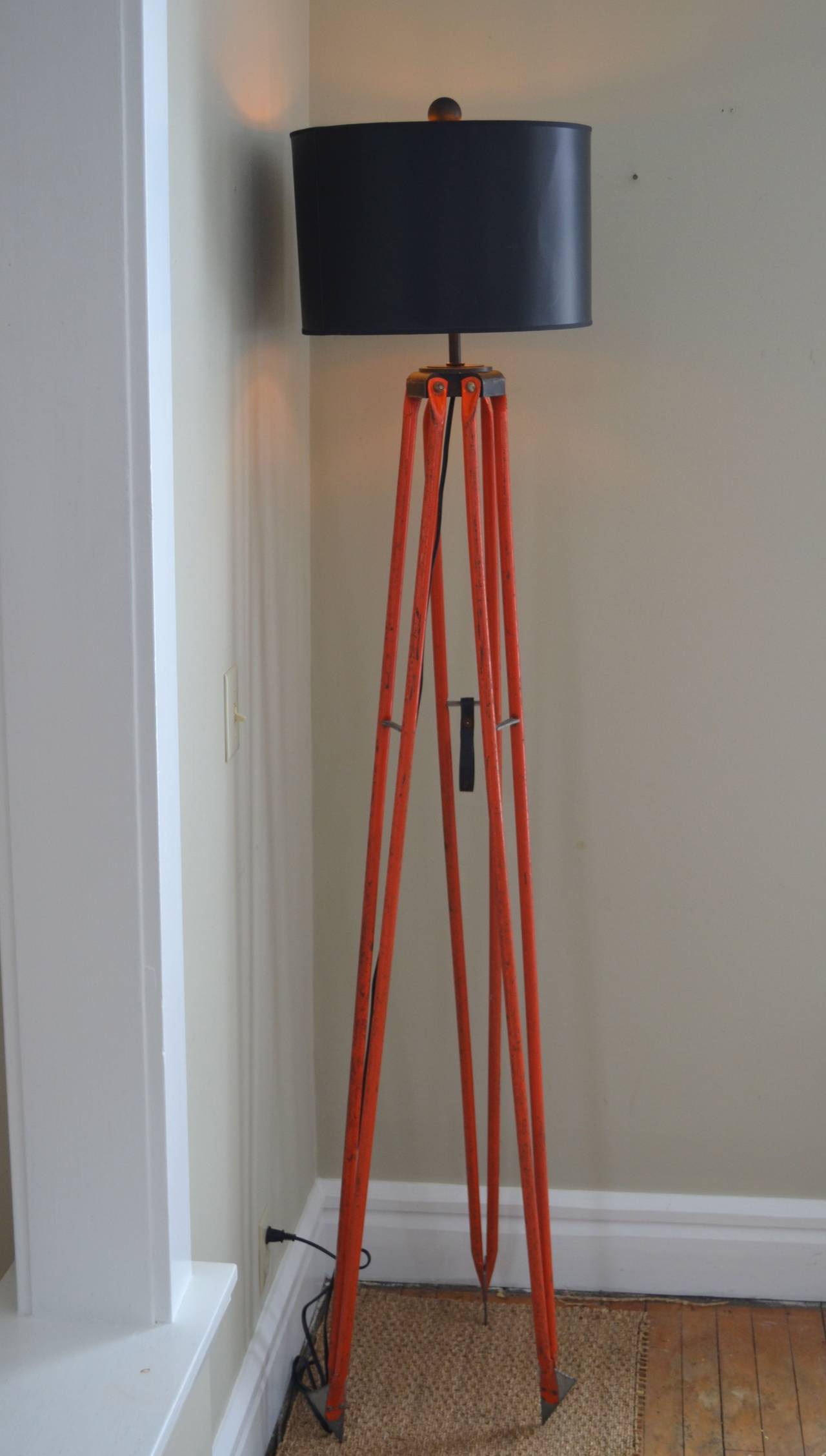 Surveyor's tripod of steel in as-found, field-tested orange paint from David White. Tall and elegant in its industrial steel stance, this floor lamp has been professionally-wired with 10' black cord, 3-way socket (150-watt maximum), 8