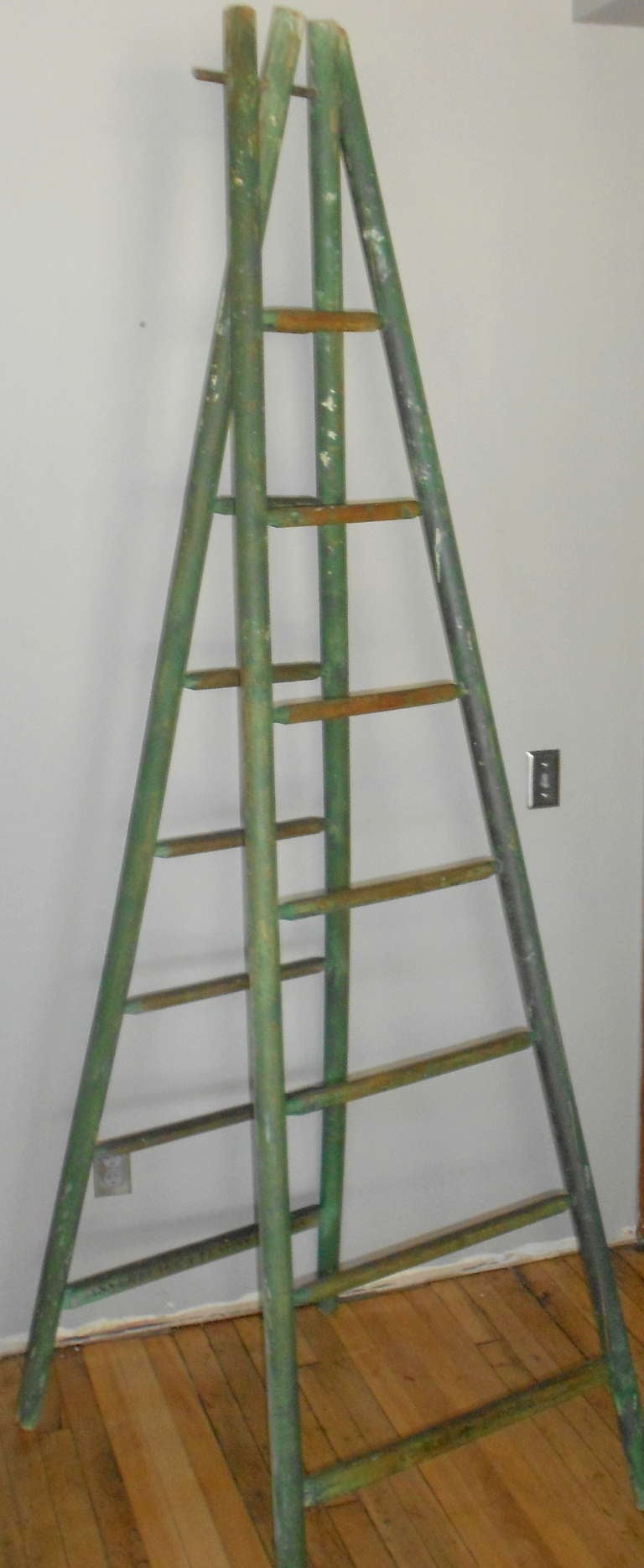 Early 20th century French country orchard ladder in as-found, faded green paint. Ladder is handmade from pine poles with oak rungs. Stands 91