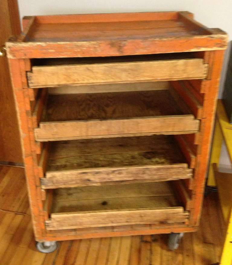 Industrial, wooden, railway cart on wheels in original orange paint, numbered on sides. Four, sliding, plywood drawers for storage. Cart moves easily on 5