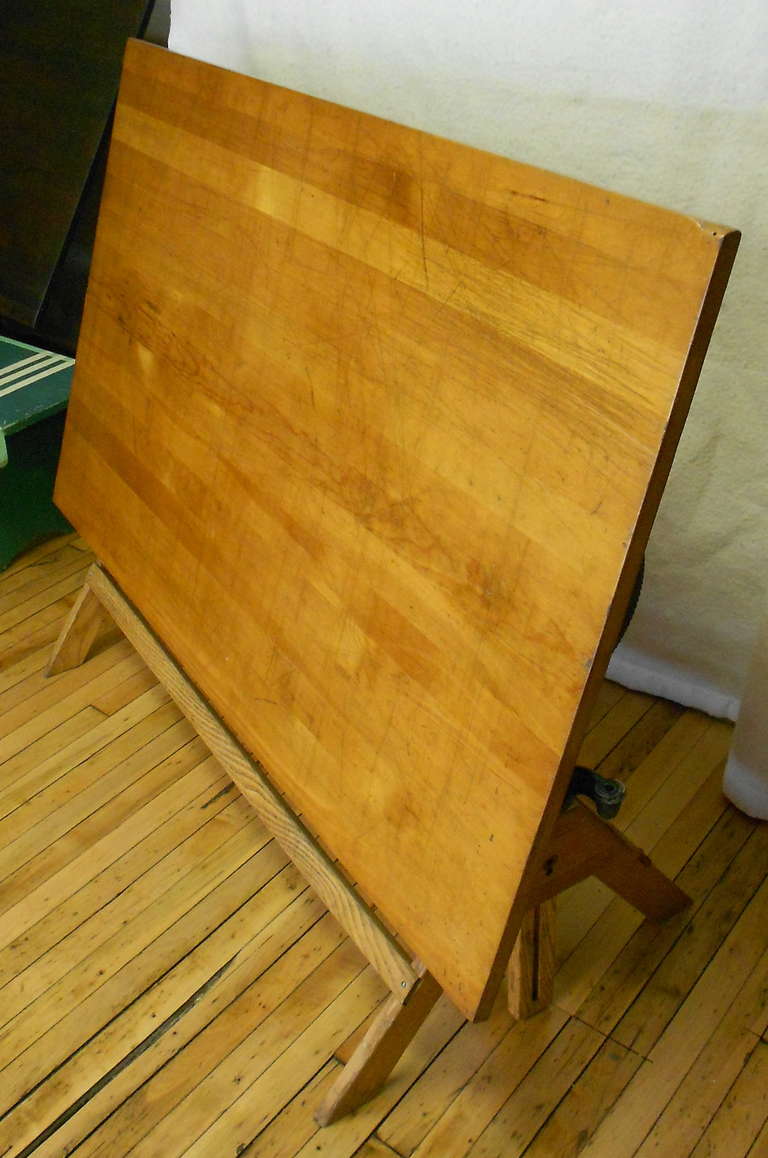 Large scale drafting table with sturdy oak base and richly-grained, reddish blond, pine top. Adjusts in height from 31