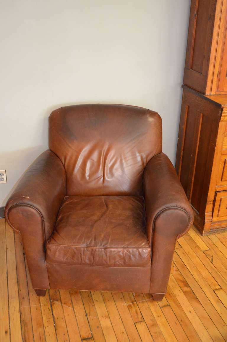 Leather club chair offers luxurious comfort and classic leather hand. Solidly built and exquisitely-appointed, this chair features leather with a velvet hand, wonderfully worn in ways that only rich living can create. The darkened areas visible in