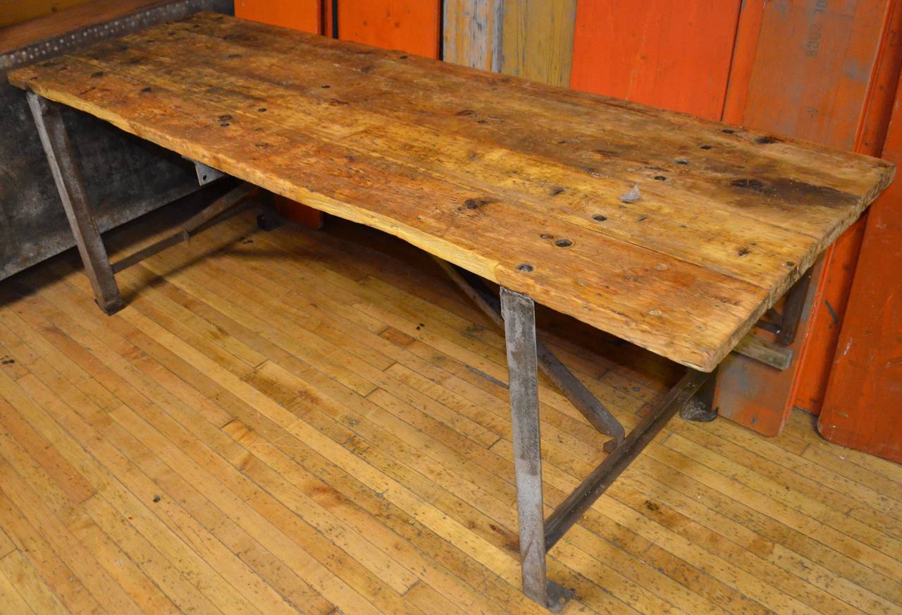 Primitive pine board work table with steel frame and strong industrial character. It currently stands 33
