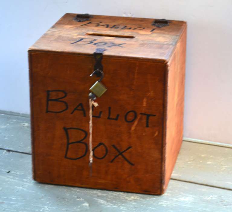 Wooden ballot box with original padlock and key. Long before digitized voting booths and hanging chads, there was the simple hand-made wooden ballet box with slot for inserting paper ballots. When the polls closed the box was pad locked, sealed with