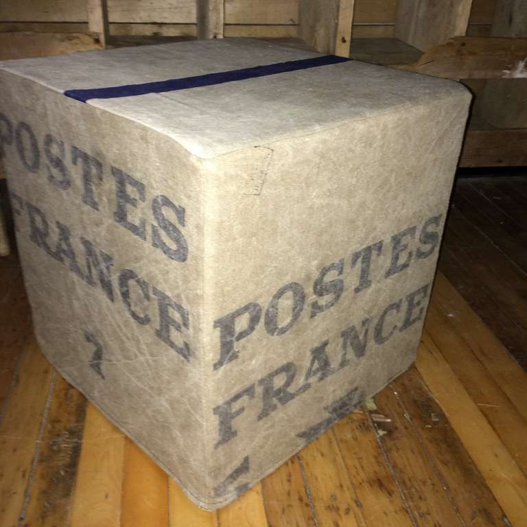 French canvas postal bag (circa 1950s) is the feature on this multi-functional pouf, ottoman, seat. Surrounds poly-foam cube that is very firm to sit on and can serve as leg rest or extra seat. Zippered for easy removal from foam for washing. Postal