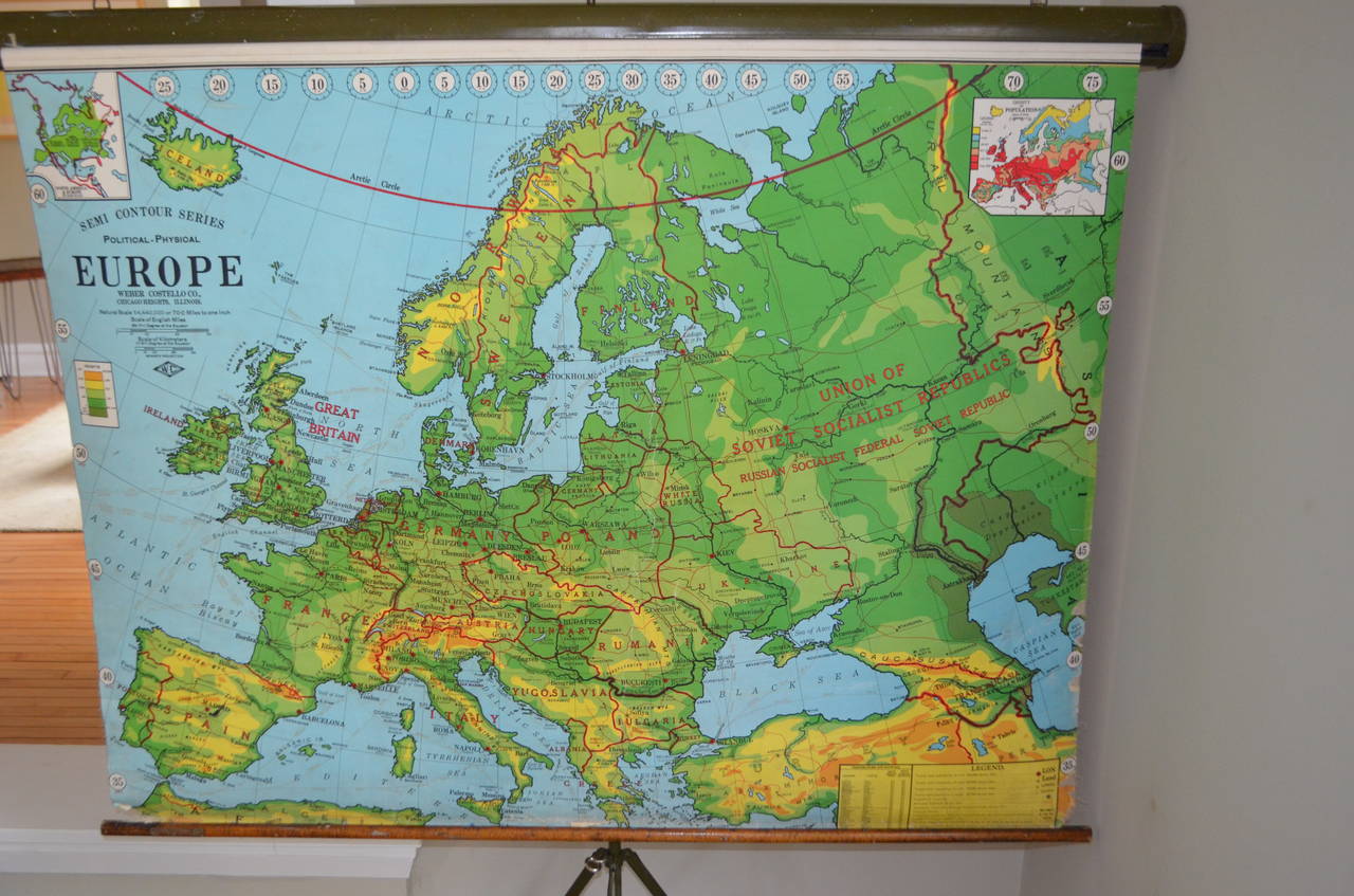 Map of Europe and its terrain in vivid colors, 1956 edition. Housed in military green steel canister from which it pulls down on wooden rod. Includes its own display stand for mobile use in and out of the classroom. May also be mounted on a wall for