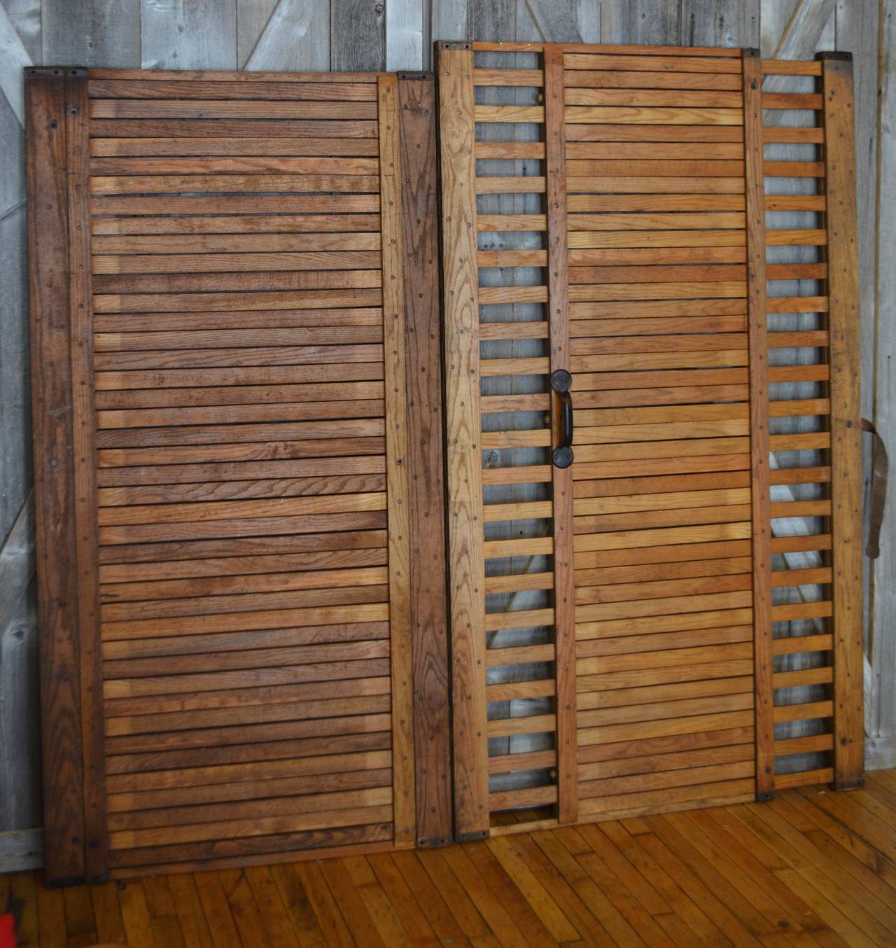 Pair of freight elevator gates of solid oak. Gate on the right expands on both sides with sliding oak panels, creating a lattice look.  Measures 38