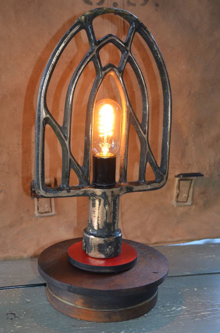 Industrial beater has been given an illuminating uplift as a table lamp mounted on an industrial pattern. Striking ambient lighting for hallway table, porch or corner of the living room. Professionally wired with UL-approved components including