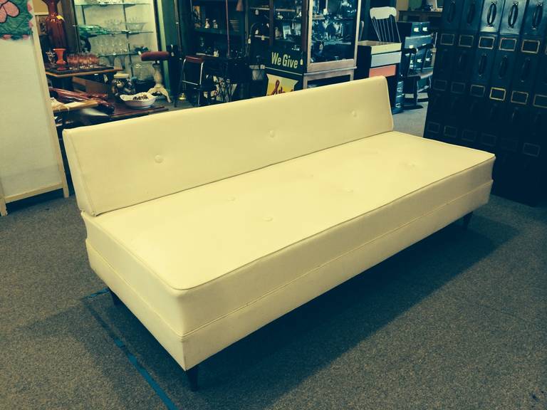 Mid century white vinyl sofa with walnut trim. Clean and sleek, simple lines.