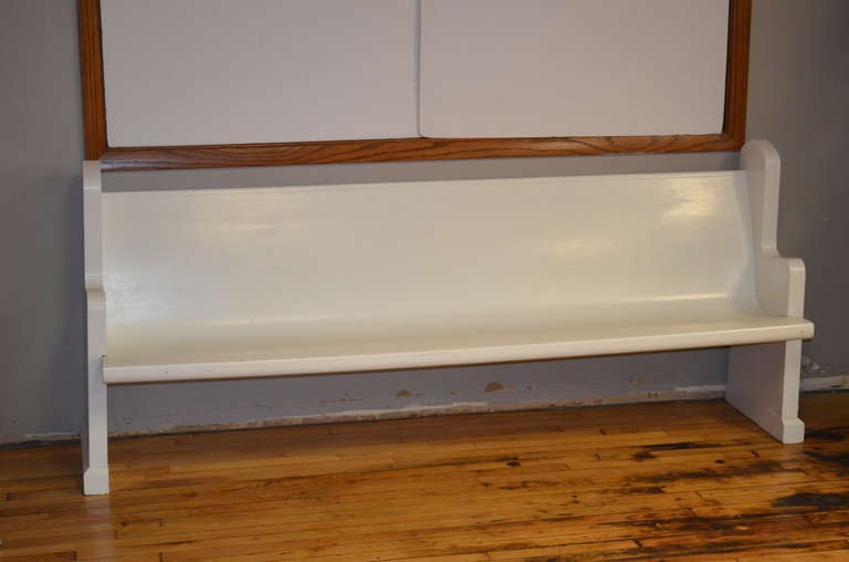 Antique church pew with soulful simplicity of line and design has been refurbished in white. Sturdy, solid and comfortable, this bench functions nicely in alcove, hallway, porch or as back wall anchor. Ideal for overflow seating restaurant waiting