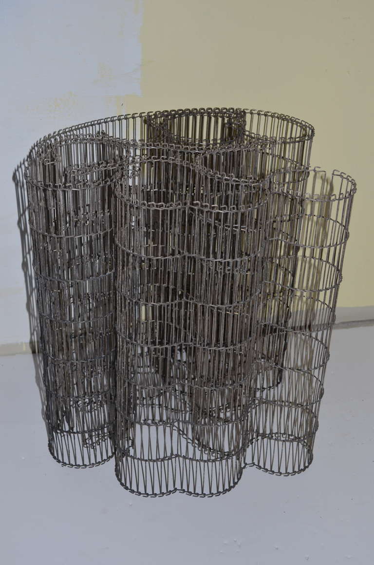 Long and curving steel wire mat that can be formed into a circular shape or woven into wall art.