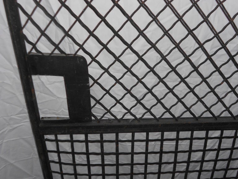 Steel Grid Bank Door was the security door to teller stations. An interesting treatment of steel solid safety with a friendly open air touch. Two distinct grid patterns woven in steel.  Pair available.
