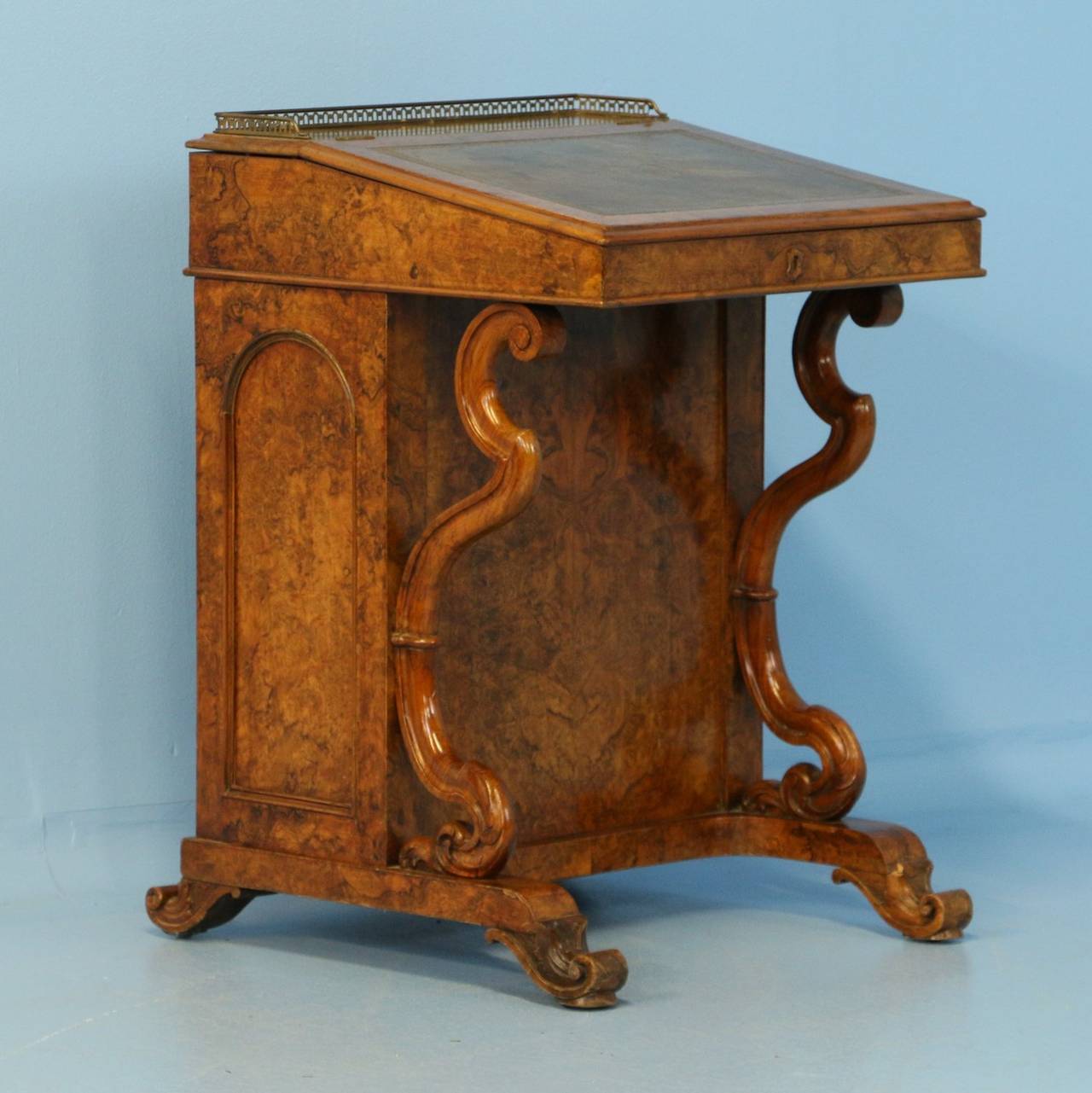 Stunning burled walnut with elaborate carved legs are the hallmark of this elegant English Davenport desk. Please examine close up photos to appreciate the beauty of the wood, which is accented inside the desk with bird's-eye maple. The leather