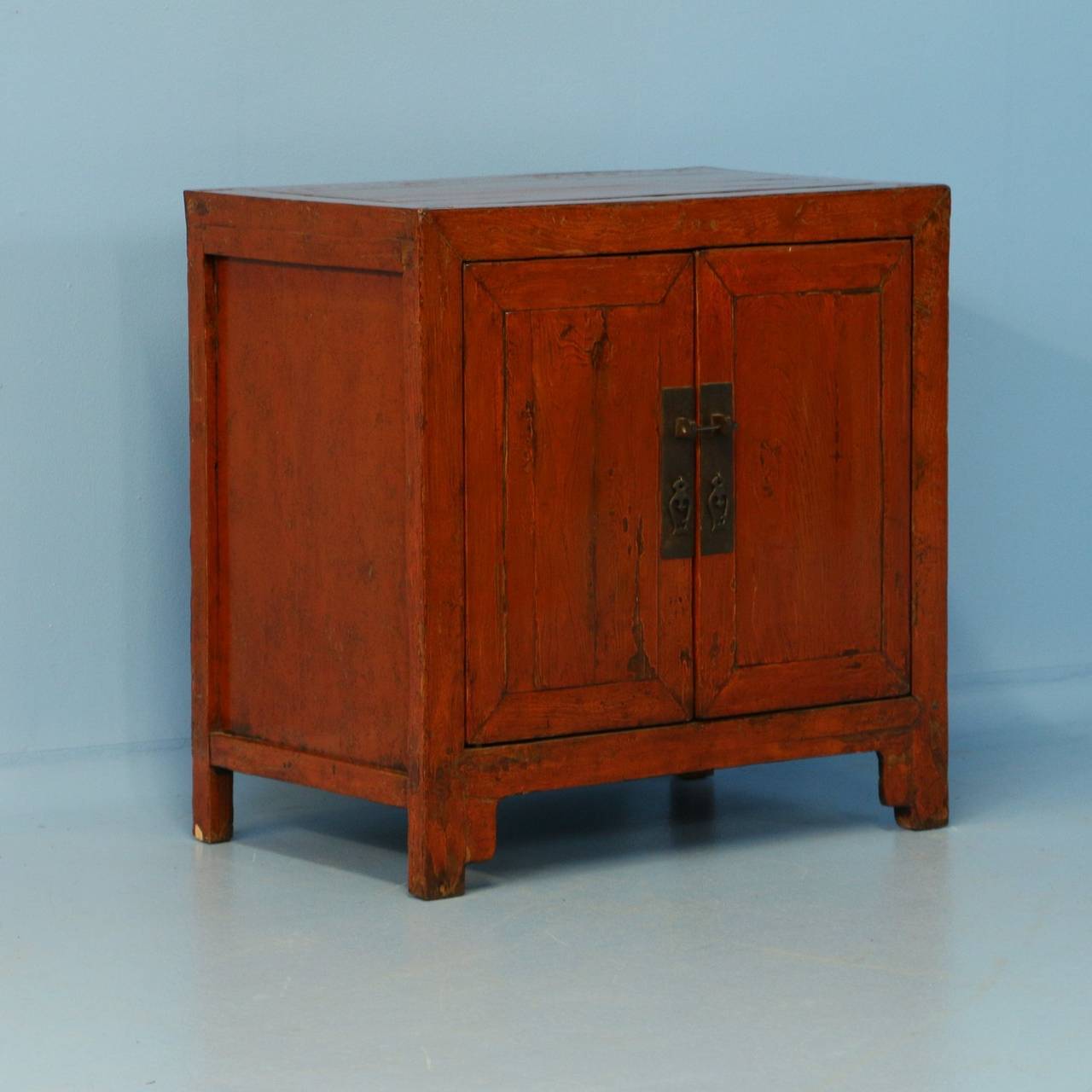 The original brick red paint comes to life with the hand-buffed lacquer finish on this Chinese sideboard. When viewing the close up photos, you will see areas where the paint has been worn down through the years of use to the natural wood below.