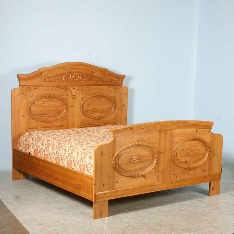 Stunning pine king bed is complete with headboard, footboard, and side rails.  The lovely carved headboard/footboard are from the late 1800's in Denmark. The pine has been  given a wax finish, bringing out the warmth  the pine.   The original